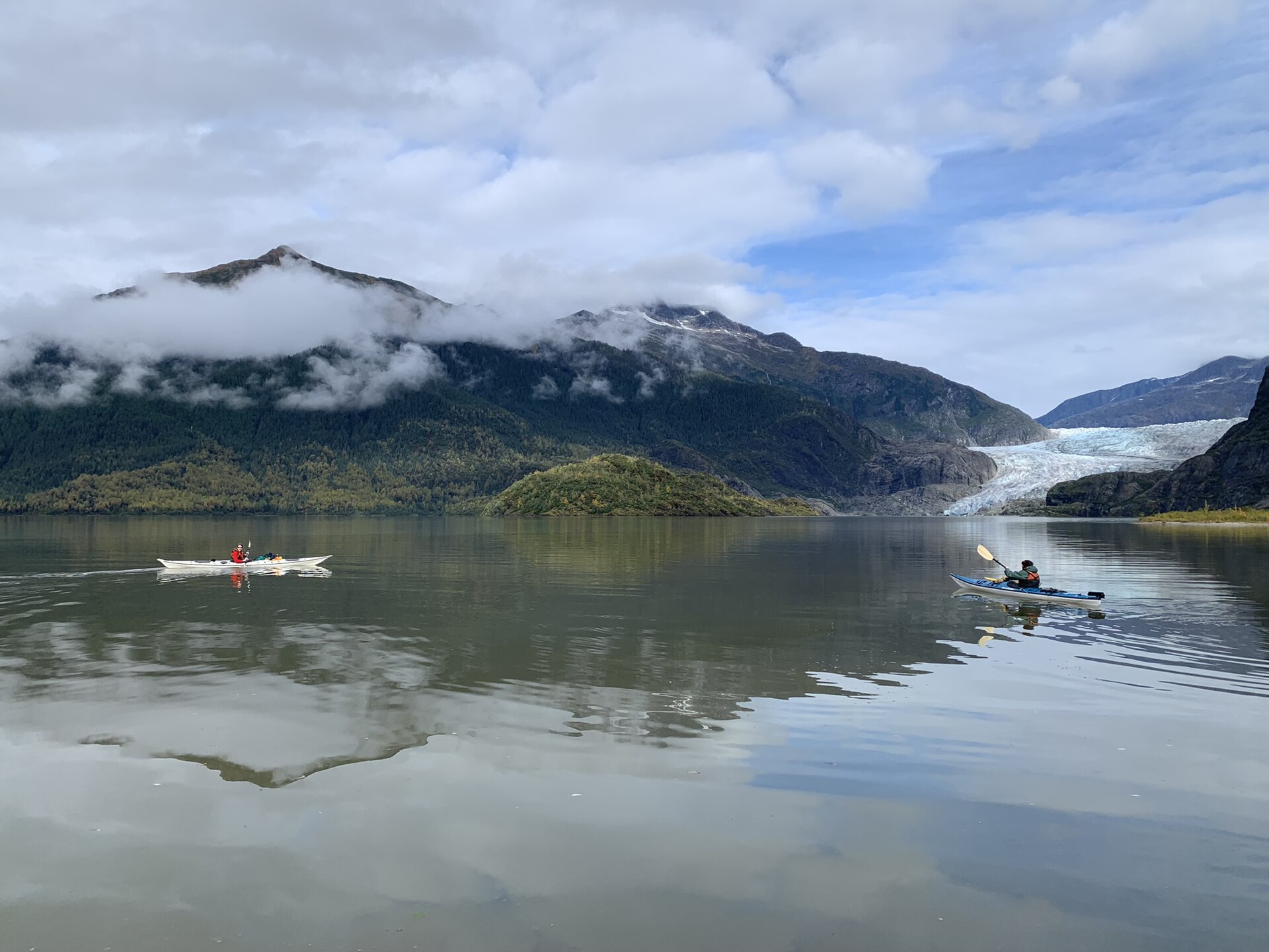 Kayaker paddling on a moody forest lake